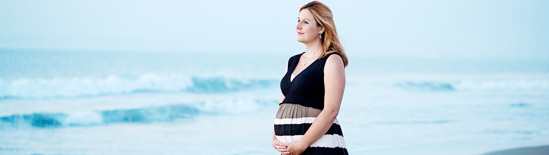 Stomiopererade gravida Amy promenerar på stranden