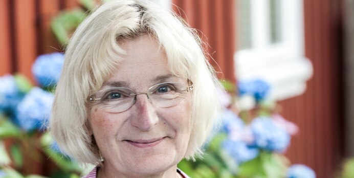 Tove står vid vattnet och ler